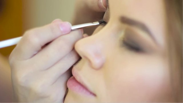 makeup artist paints the eyes