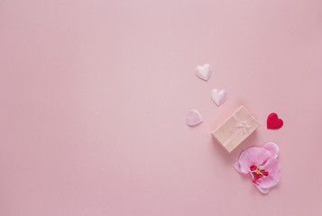 Pink background with gift box, orchid flowers and Valentine hear