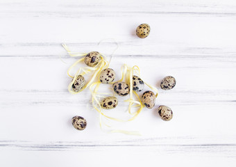 Easter festive background, quail eggs on a white wooden table. Flat lay, top view, minimal concept