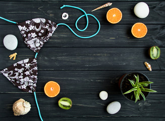 Holiday elements: swimsuit, stones, seashells, fruits. Travel photo, flat lay, top view