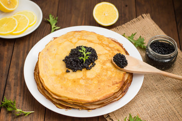 Black caviar on Russian pancakes - blini. Selective focus.