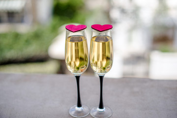 two glasses of champagne and red hearts 