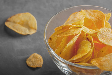Potato chips in bowl with tomato juice in glass