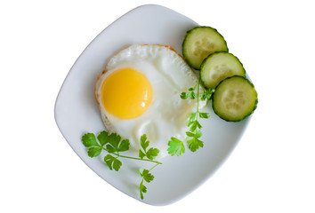 Fried fried eggs with cucumbers on a plate on white background  top view