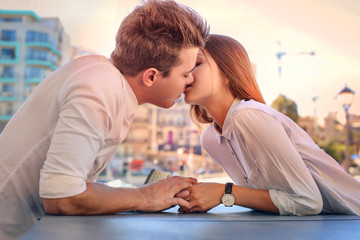 Teen couple kissing by the table