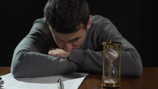 Doubtful young man uncertain about signing document, starting risky business