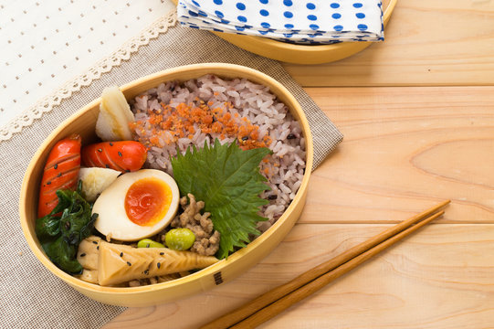 A Colorful And Delicious Looking Bento Consisting Of Stir Fry Bamboo Shoot With Ground Pork, Brown Rice, Boiled Egg, Sausage And Salmon Fuirkake Seasoning