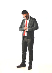 A bearded man in a business suit and red tie.