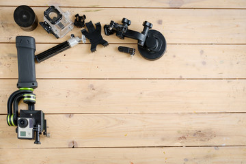 Action camera on the wooden table with a stabilizer and other accessories