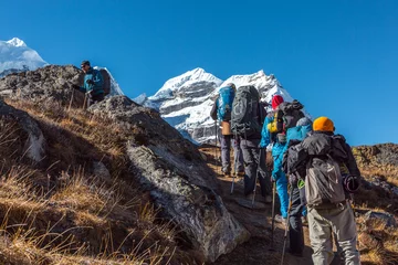 Foto op Plexiglas Groep wandelaars die op steile bergweg lopen © alexbrylovhk