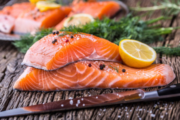 Salmon Fish..Raw salmon fillet pepper salt dill lemon rosemary on wooden table.