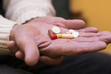 Senior man with pill in hand