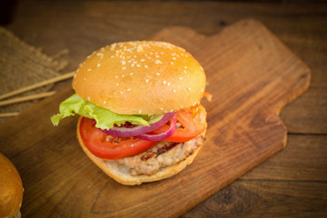 Cheese burger with grilled meat, cheese, tomato, on craft paper