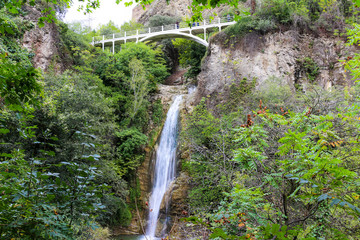 Mountain waterfall with bridge