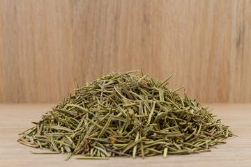 Rosemary medicinal and aromatic plant on wooden background (Rosmarinus officinalis)