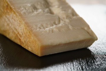 big chunk of italian parmesan cheese on slate board, simple rustic photo