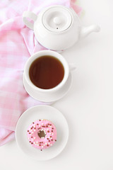 Delicious donuts with cup of tea on white background