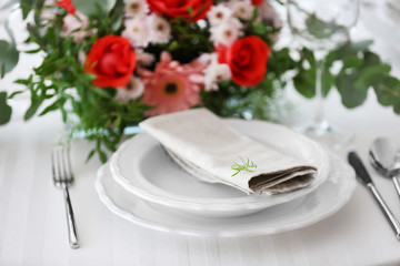 Elegant table setting with beautiful flowers, closeup