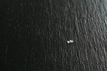 coarse sea salt crystals on slate background, shallow focus