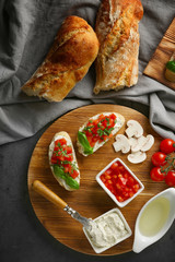 Fresh ingredients for delicious bruschetta and napkin on table