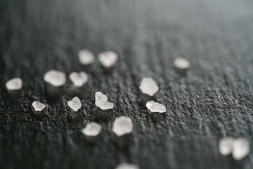 coarse sea salt crystals on slate background, shallow focus