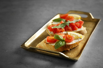 Tray with delicious Italian toasts on grey table
