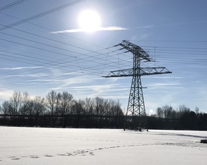 Strommast im Winter - mit Schnee bei Sonnenschein
