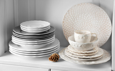 Different clean dishes in cupboard in the kitchen