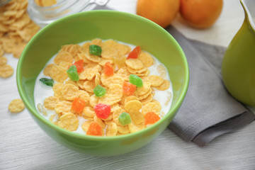 Tasty cornflakes with candied fruit on table