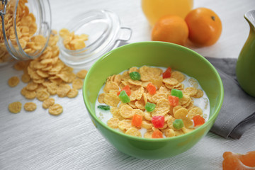 Tasty cornflakes with candied fruit on table