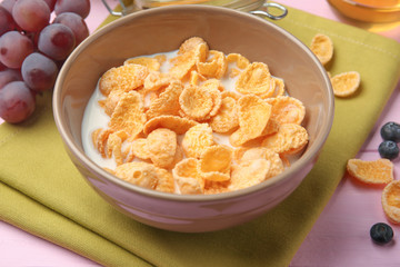 Tasty cornflakes with berries on pink background