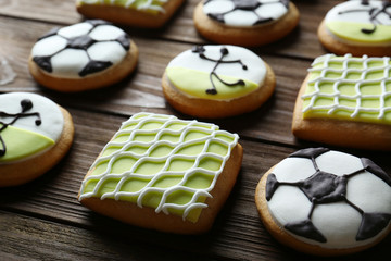 Tasty football cookies on wooden table, closeup