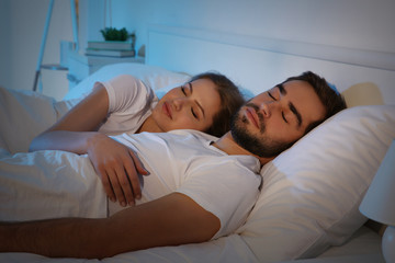 Young cute couple sleeping together in bed