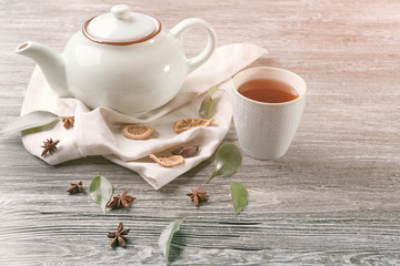 Teapot and cup with tea on wooden background