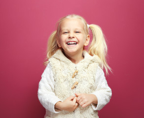Funny little girl in warm clothes on color background
