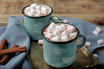 Cups of hot cocoa with marshmallows on tray, closeup