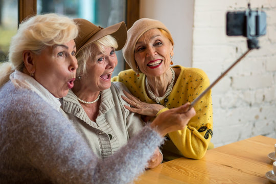 Three women taking selfie. Senior ladies indoor. Save friendship after many years.