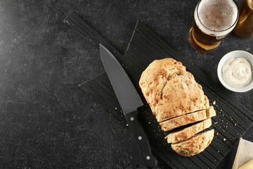 Board with tasty loaf of beer bread on table