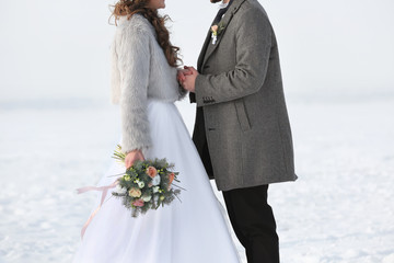 Happy wedding couple outdoors on winter day