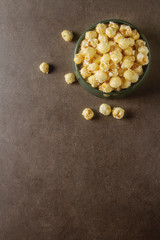 Sweet popcorn in a bowl. Gray background. Watch a movie.