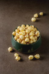 Sweet popcorn in a bowl. Gray background. Watch a movie.