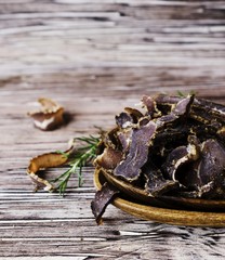jerked meat, cow, deer, wild beast or biltong in wooden bowls on a rustic table