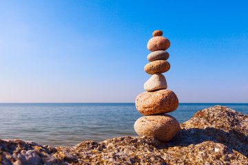 Fototapeta na wymiar stones balance on the edge of a cliff. Concept of balance and harmony