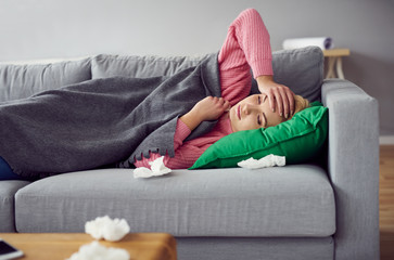 Sick woman lying on the sofa in living room