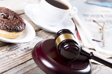 Family law concept. Gavel, newspaper and coffee on wooden table 