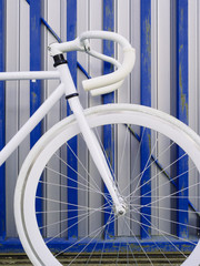 Naklejka premium White bicycle of city fixed gear on white and blue wall.