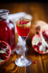 sweet pomegranate alcoholic cordial in the decanter with a glass