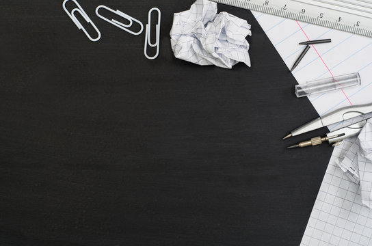 School supplies border on black chalkboard background. Top view product photograph with copy space for text or design. Back to school, education concept