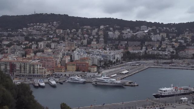 City view with pier on the Cote d'Azur with different yachts and boats. Cityscape with beautiful buildings in autumnal cloudy day. nice france.