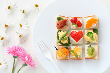 ハート型いちごのオープンサンドイッチとマーガレットとガーベラ